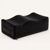 Ostinea Cushion in black velvet, shown at a three-quarter angle with raised contours and a recessed center.