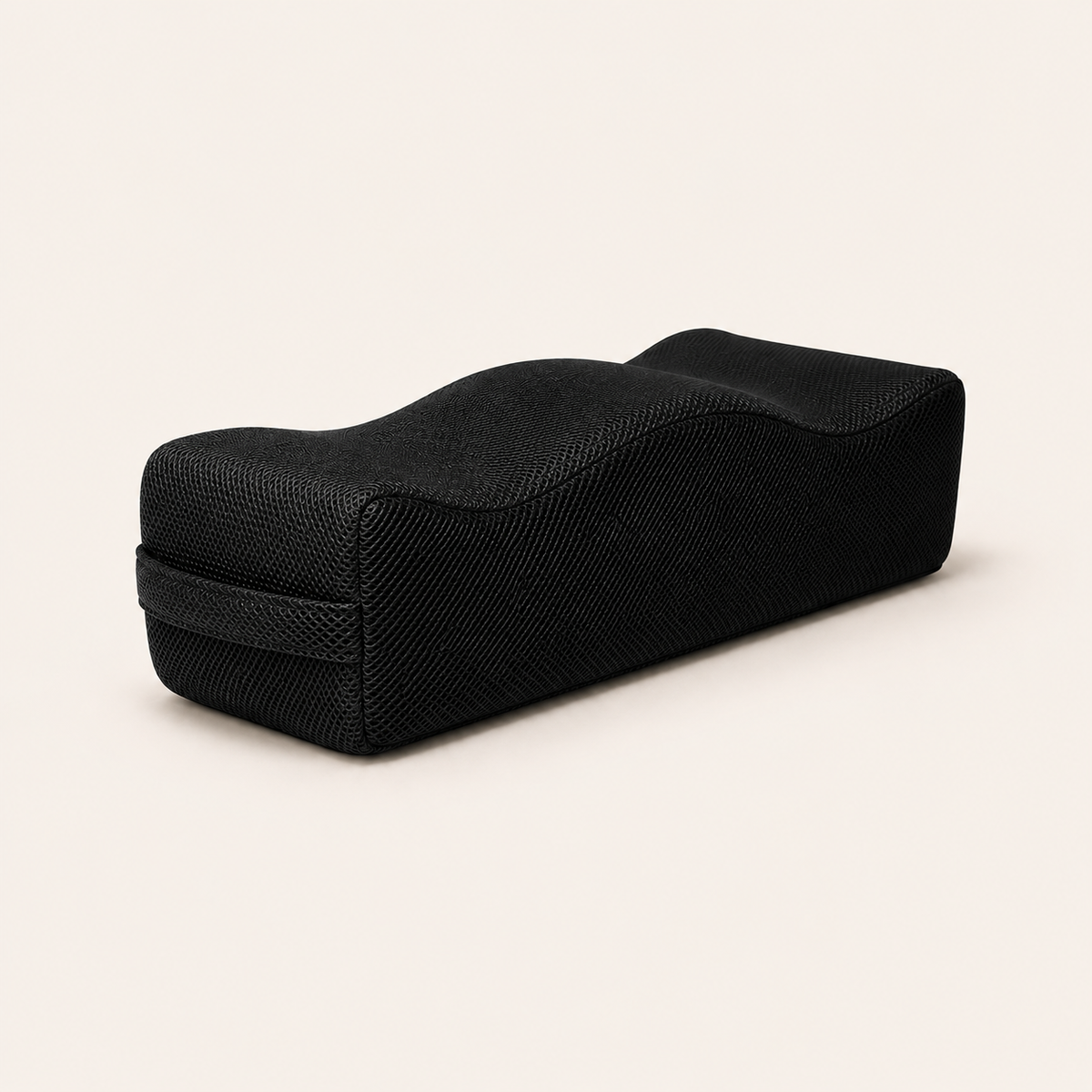 Ostinea recovery support cushion in three-quarter view showing its contoured shape and black mesh cover.
